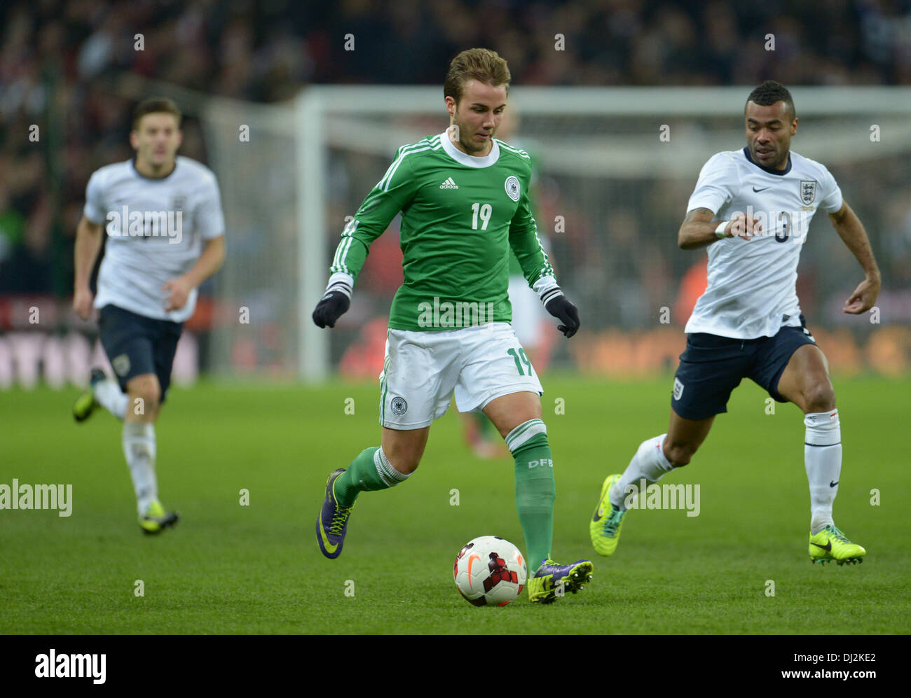 London, UK. 19th Nov, 2013. England's Ashley Cole (R) and Germany's Mario Goetze (C) vie for the ball during the friendly soccer match between England and Germany at Wembley Stadium in London, England, 19 November 2013. Photo: Andreas Gebert/dpa/Alamy Live News Stock Photo