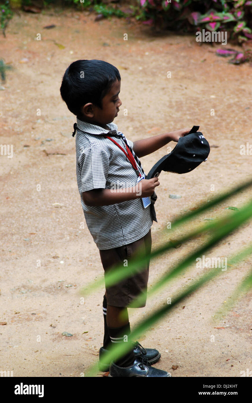 School boy about to wear cap Stock Photo