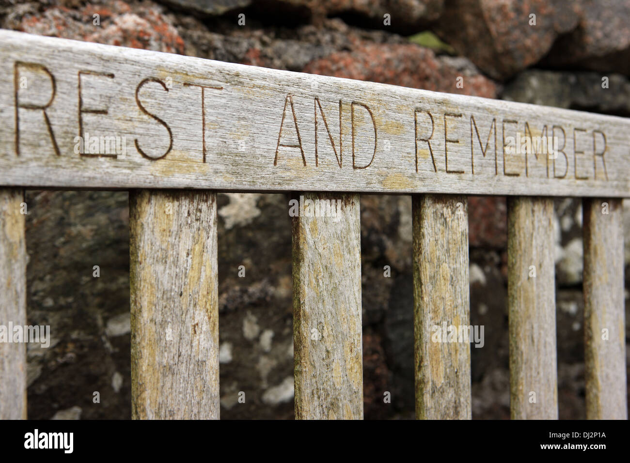 Rest and Remember carved into the back of a bench on the Hebridean island of Iona Stock Photo