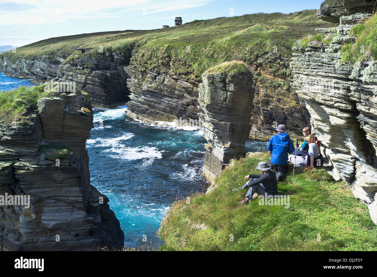 dh Stanger Head FLOTTA ORKNEY Hikers on sea cliff path Cletts stone stacks hiking scotland uk coastal hiker coastline cliffs Stock Photo