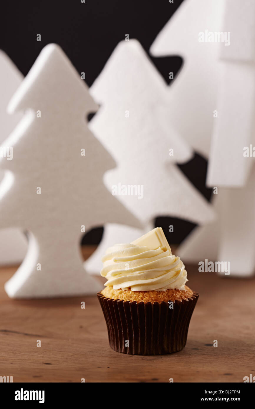 White chocolate cupcake on white Christmas trees background Stock Photo