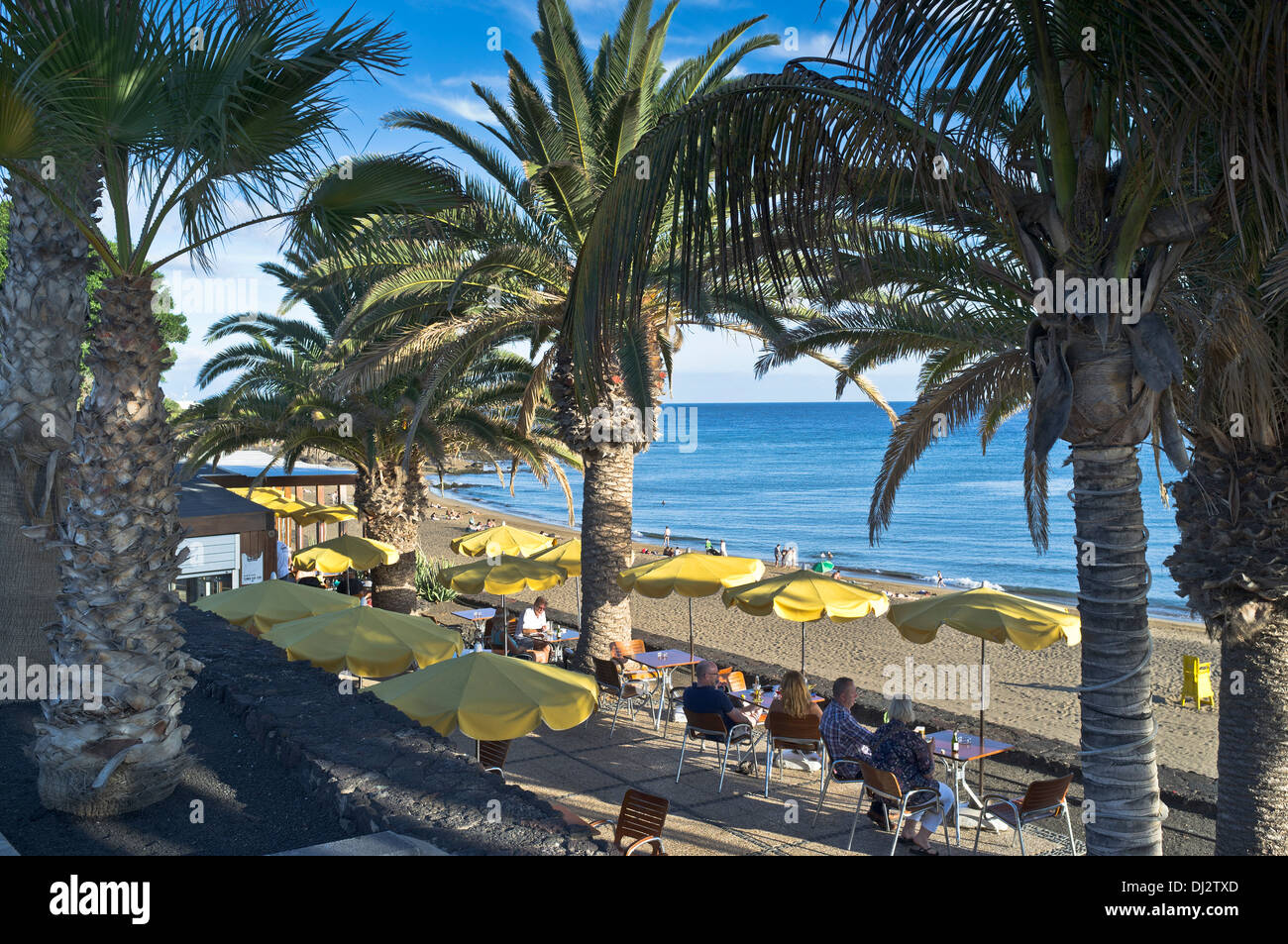 dh Beach PUERTO DEL CARMEN LANZAROTE Tourists sitting cafe tables overlooking beach alfresco cafes holiday Stock Photo