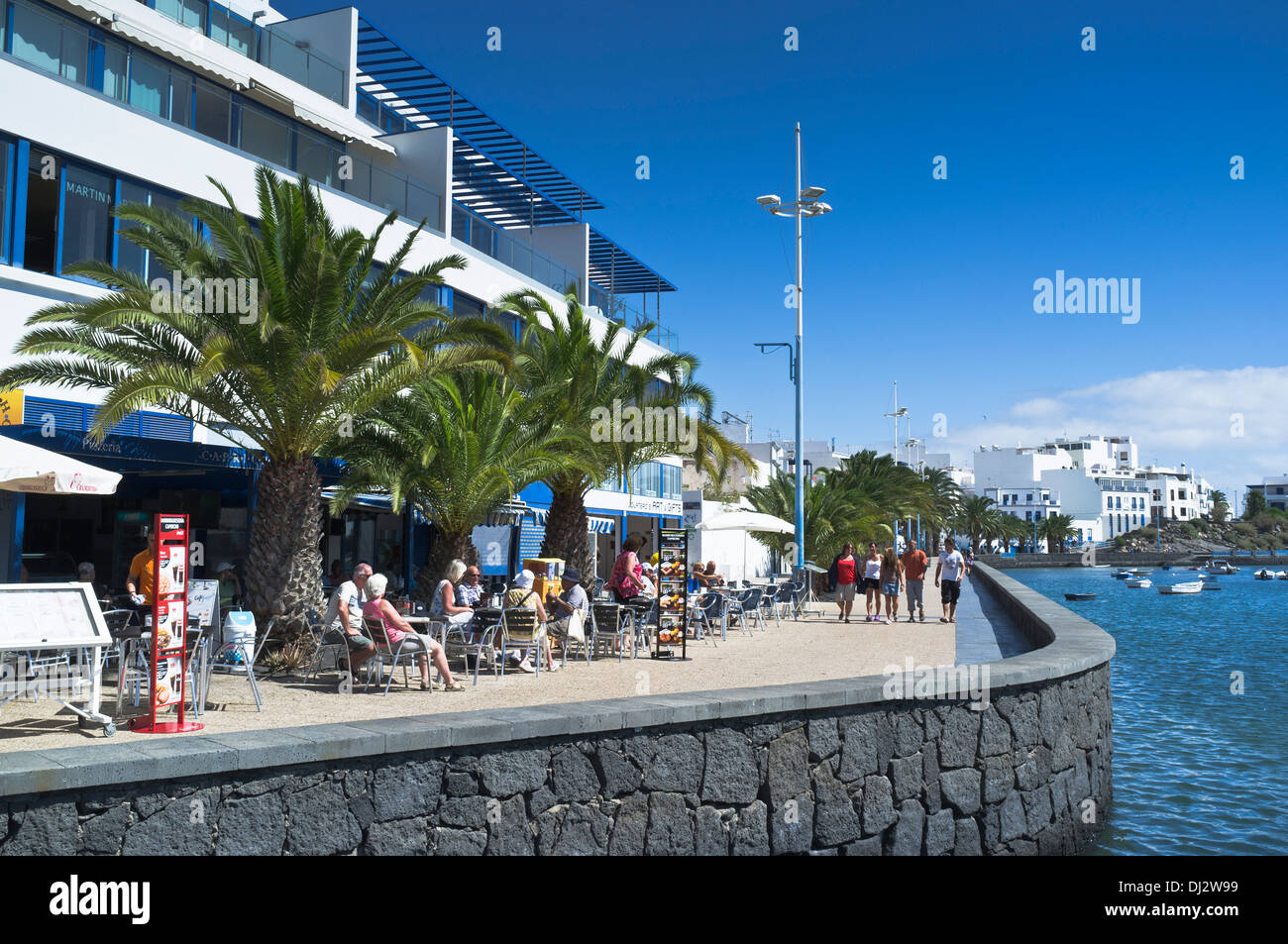 dh Calle Ribera del Charco ARRECIFE LANZAROTE Tourist sitting outdoor cafe inner harbour lagoon alfresco cafes promenade Stock Photo