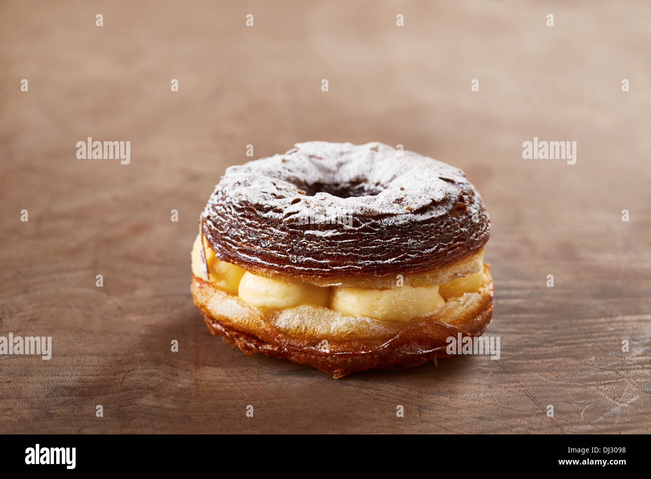 Cream stuffed croissant and doughnut mixture on wooden table Stock Photo