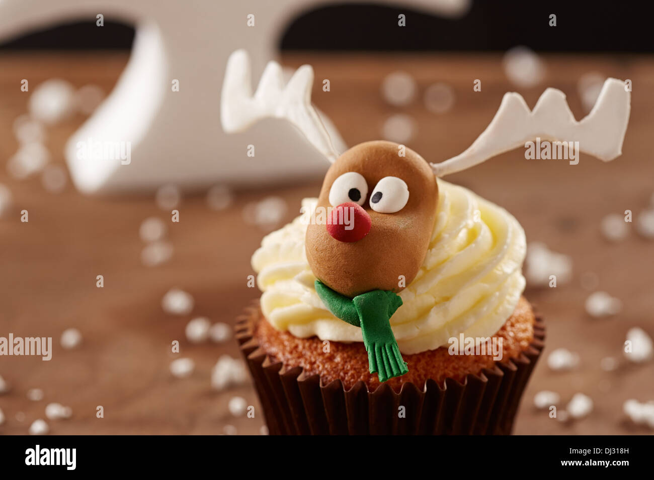 Rudolph reindeer cupcake on Christmas tree background Stock Photo