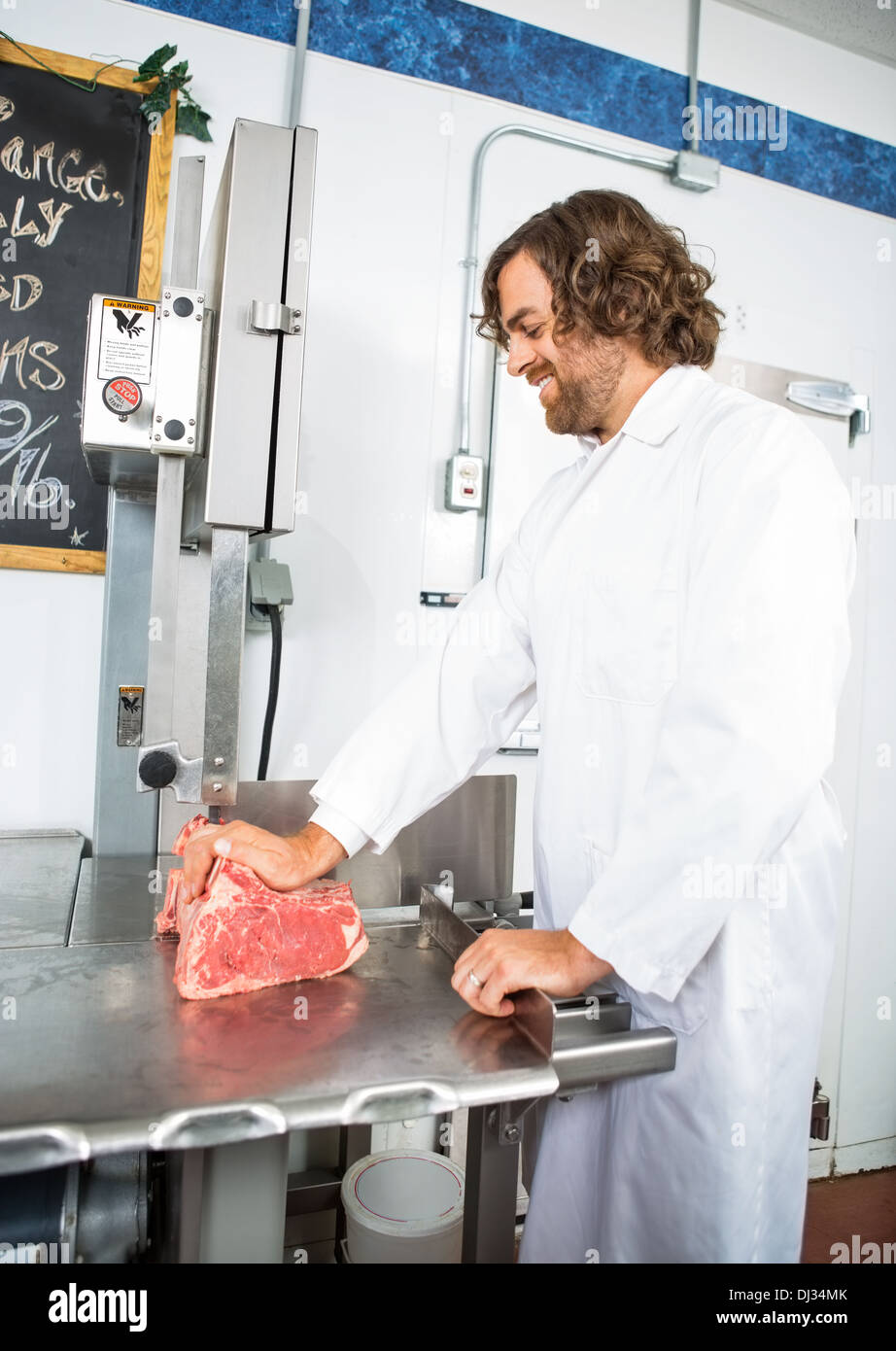 Smiling Butcher Slicing Meat In Machine Stock Photo Alamy