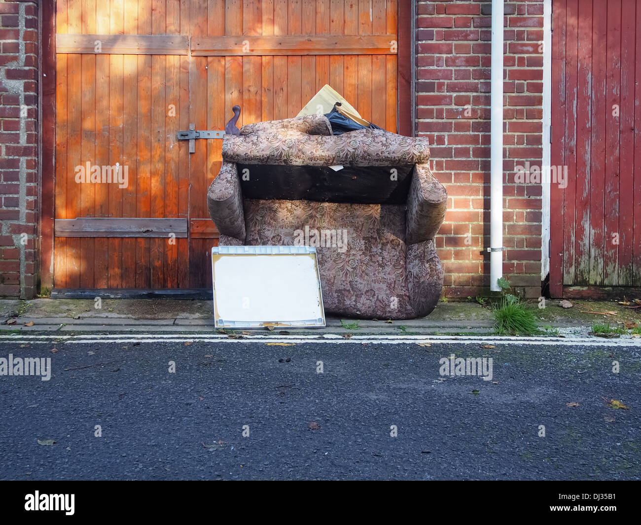 Sofa dumped and discarded on a backstreet Stock Photo