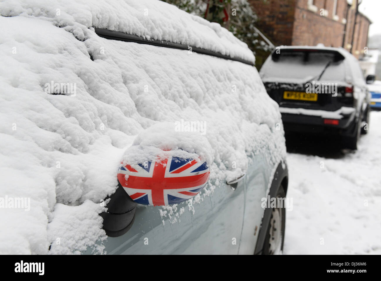 British winter weather snow covered Mini car with Union Jack wing mirror 2013 Stock Photo