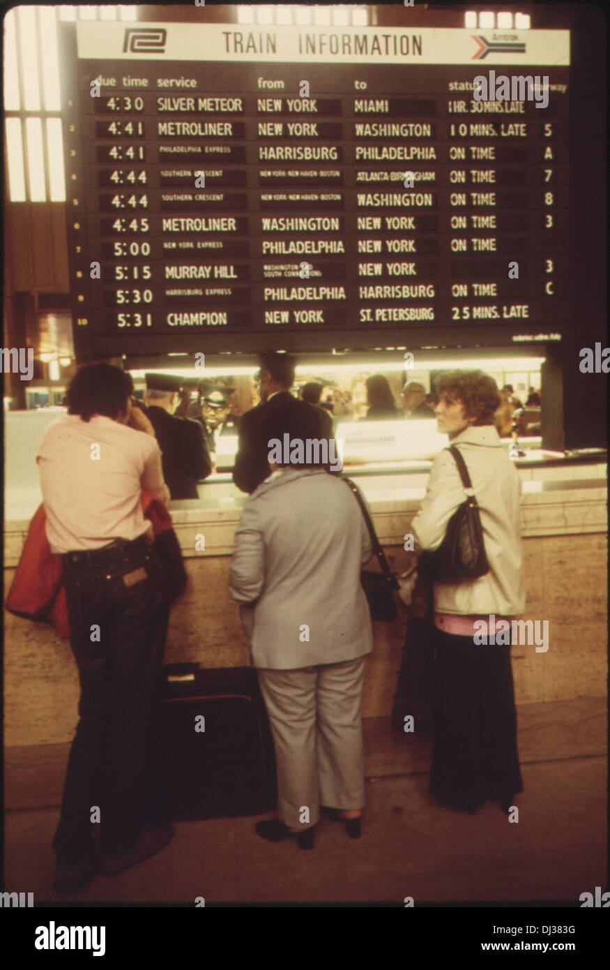 AMTRAK PASSENGERS STOP FOR TRAIN INFORMATION IN THE MAIN HALL OF THE