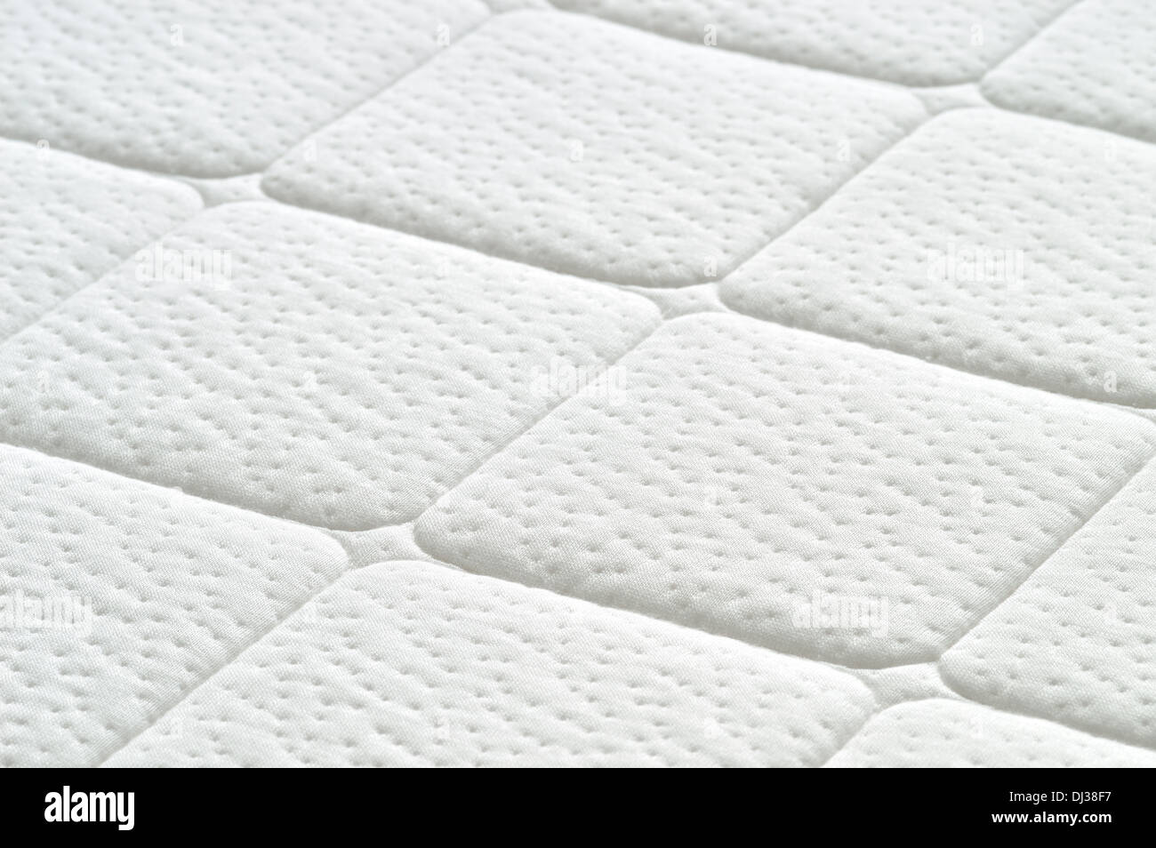 Close-up of white mattress texture. Patter of quilted material. Comfortable mattress. Copy space. Stock Photo