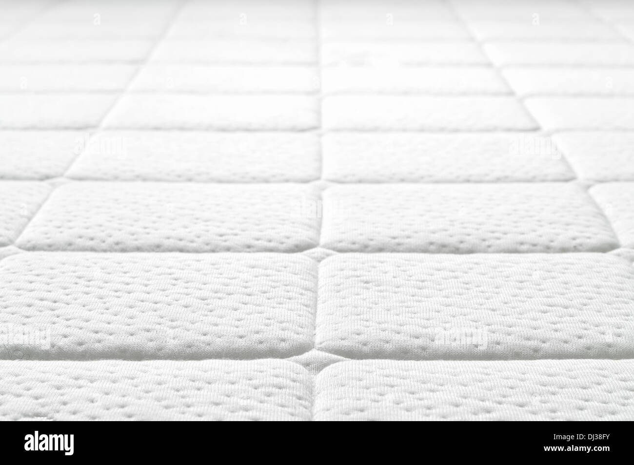 Close-up of white mattress texture. Patter of quilted material. Comfortable mattress. Copy space. Stock Photo