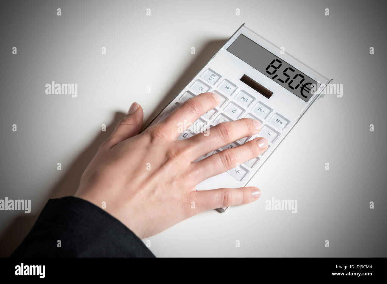 Female hand with calculator, indicating the planned German minimum wage of 8.50 € Stock Photo