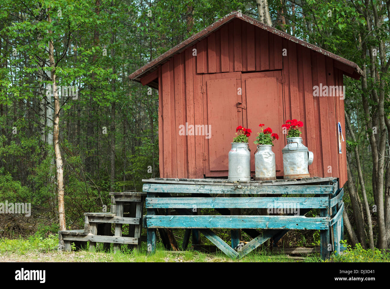 Decoration with milk canisters in front of small barn in Finnish Lapland. Stock Photo