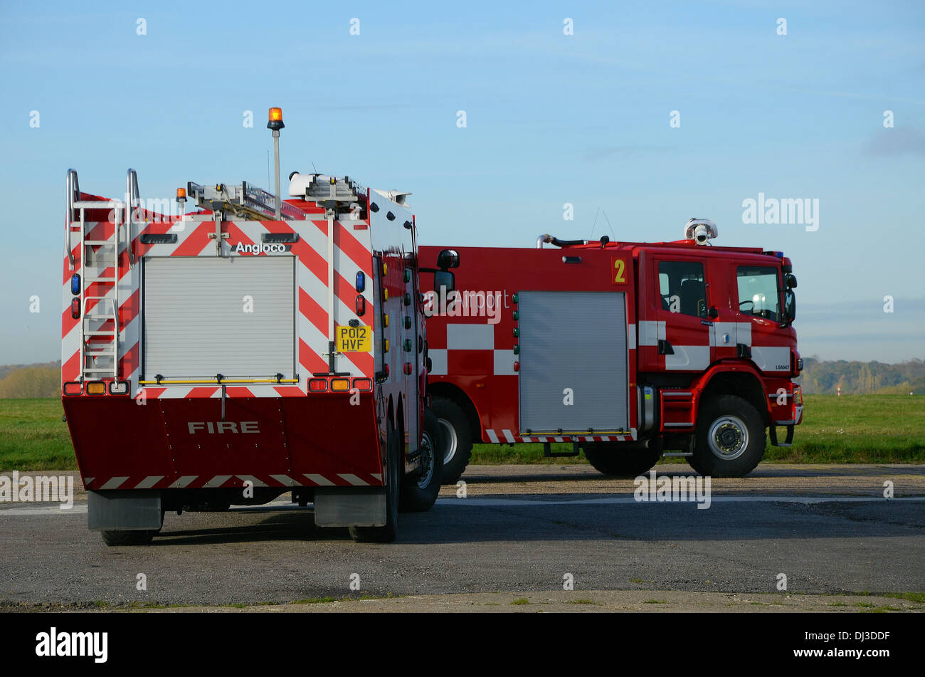 Two airport fire engines drive out to the airport taxiway leading to the runway on a practice run. London Southend Airport emergency vehicles Stock Photo