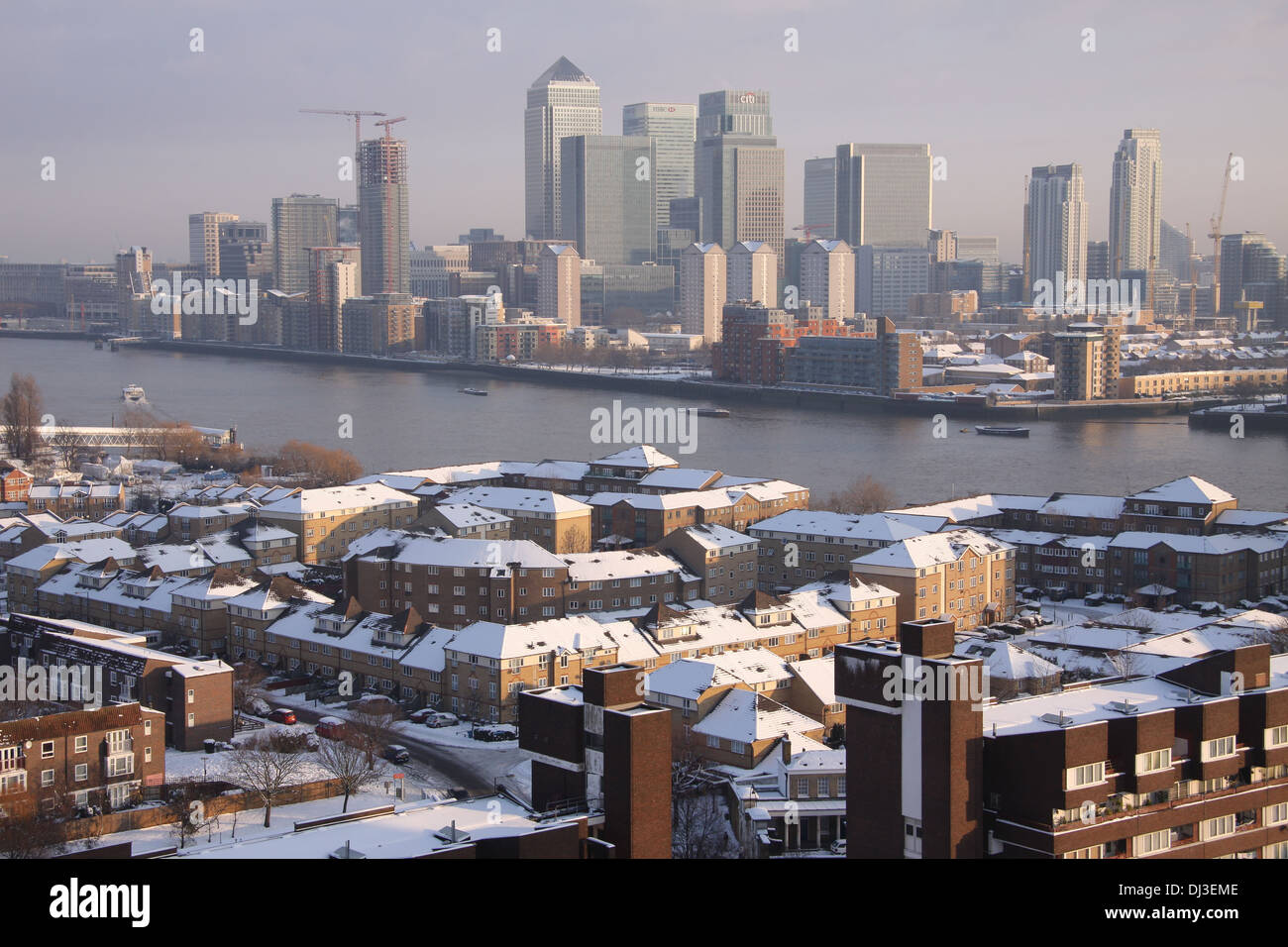 Canary Wharf buildings and Surrey Quays housing covered in snow during winter in London, UK. Stock Photo