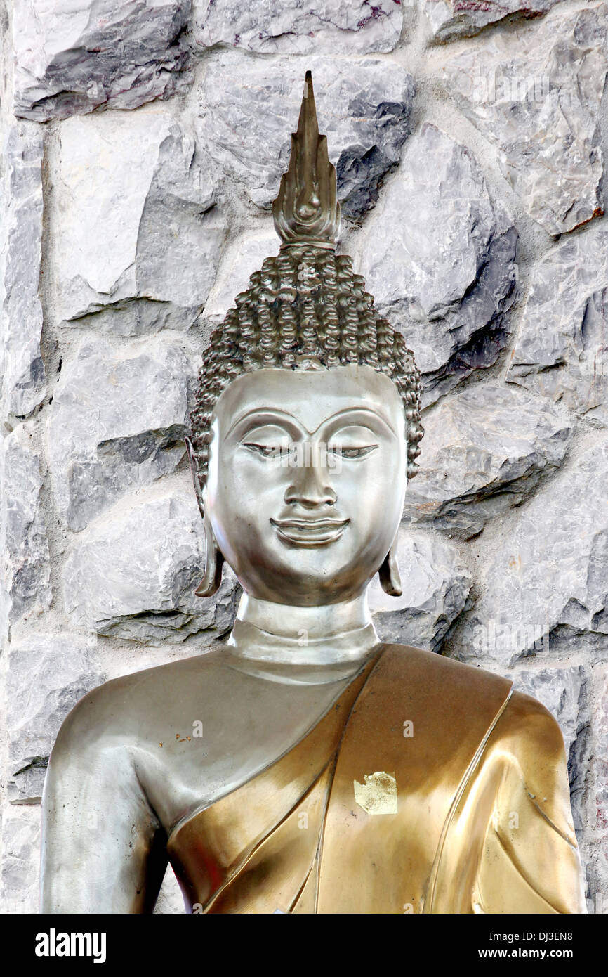 Picture Buddha statue in the background of stone wall. Stock Photo