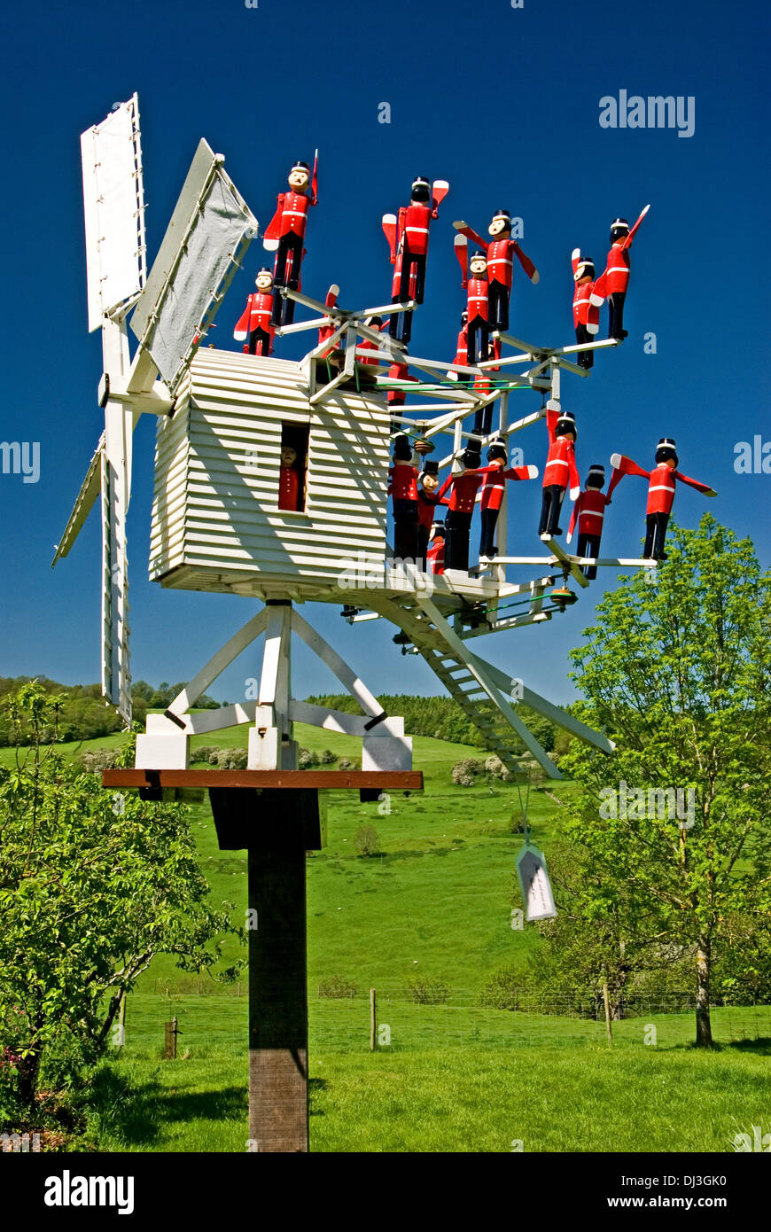 Unique timber weather vane in the shape of a windmill, with toy soldiers in red uniforms acting as a counter balance. Stock Photo