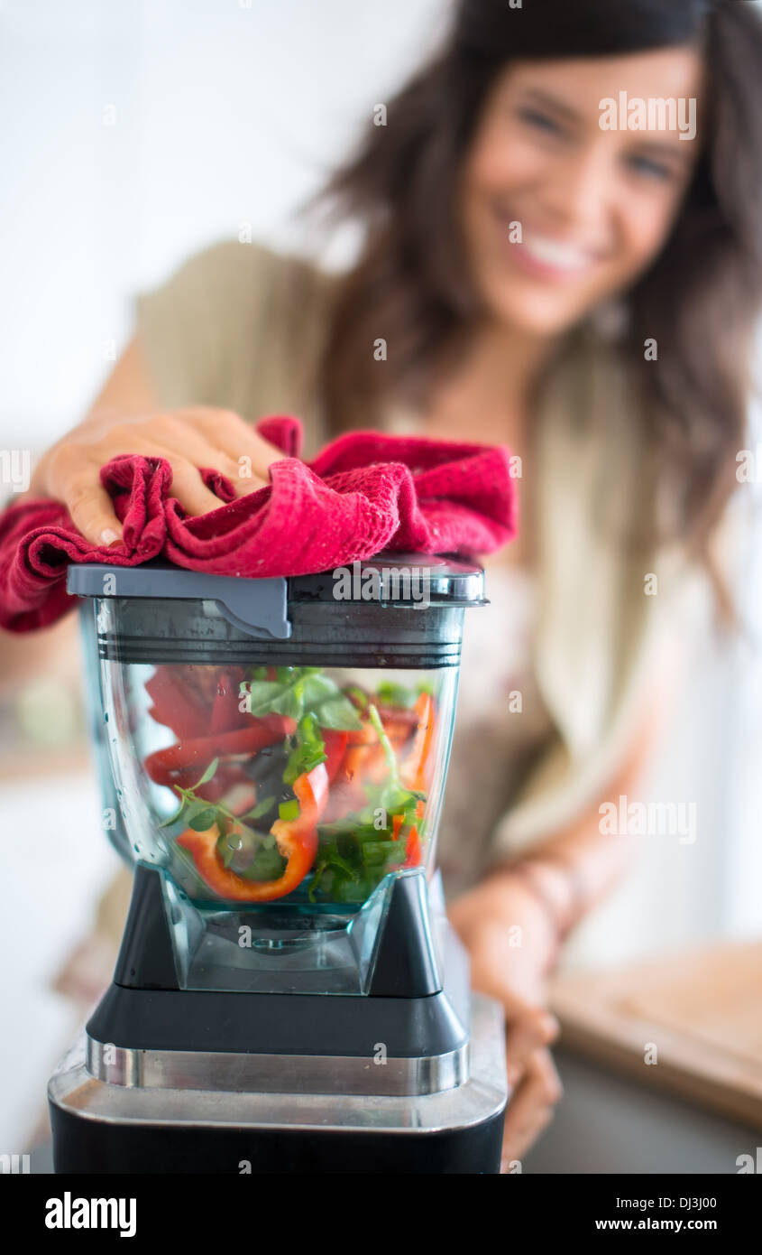 Portrait of a girl using the blender to prepare raw tomato sauce Stock Photo