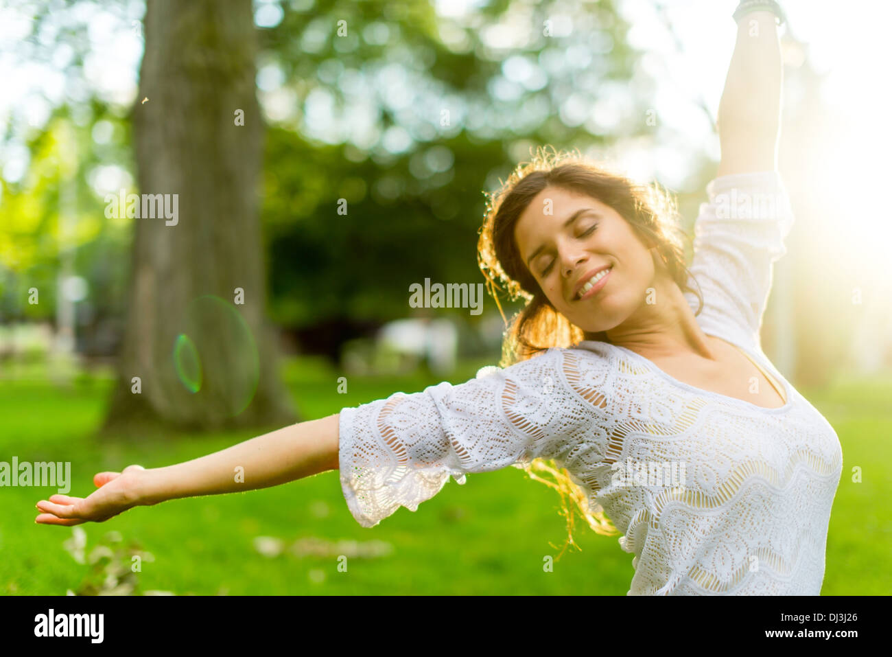 Beauty portrait of an attractive multi-ethnic girl enjoying warmth in a summer sunset. Sun Flare serie Stock Photo