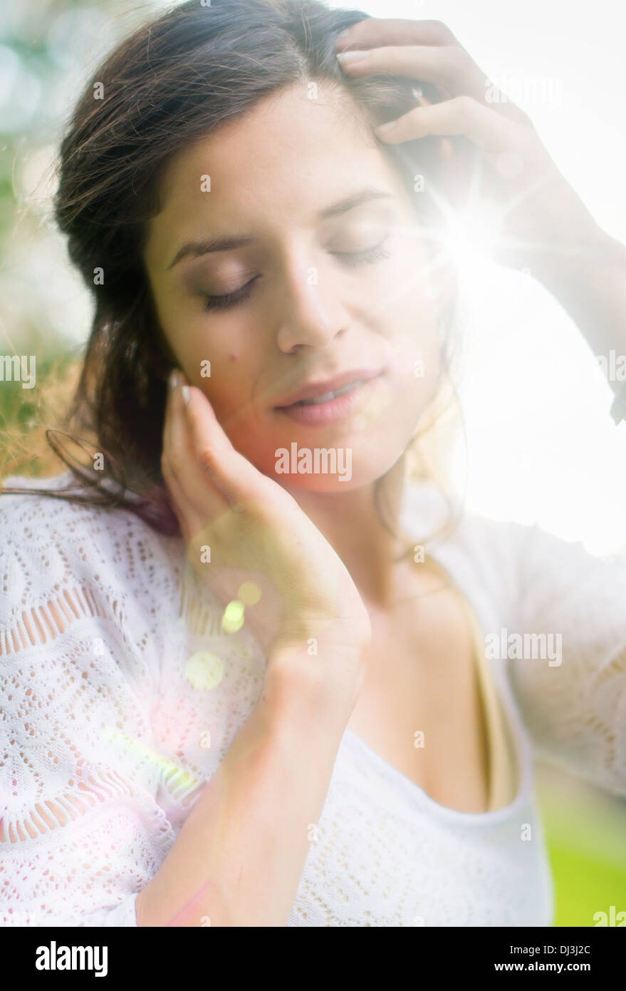 Beauty portrait of an attractive multi-ethnic girl enjoying warmth in the summer sunset. Sun Flare serie Stock Photo