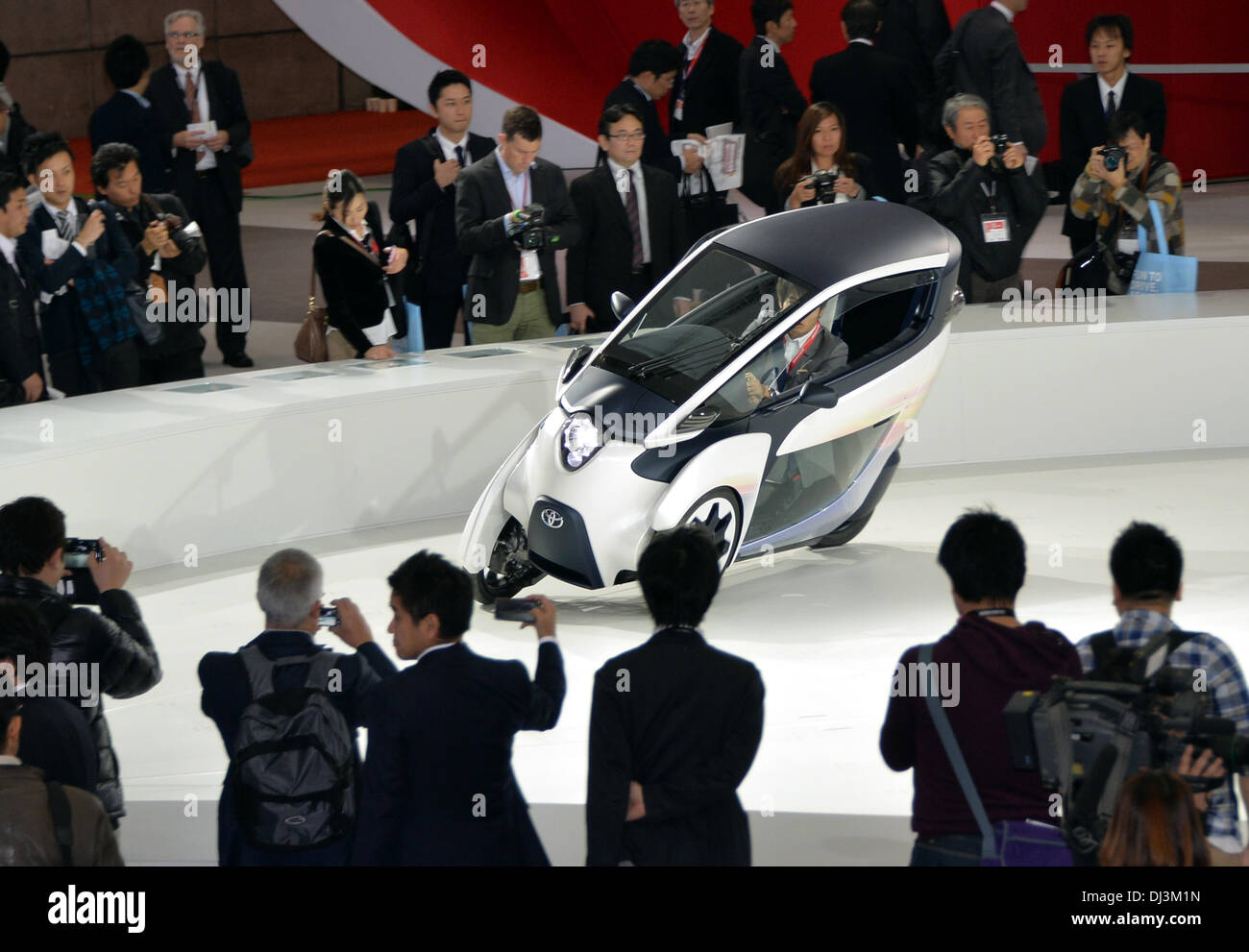 Tokyo, Japan. 20th Nov, 2013. Toyota Motor Corp., demonstrates its i-Road, an electric trike, during the Tokyo Motor Show on Wednesday, November 20, 2013. The biennial event showcases Japanese automakers' latest electronic technology and eco-friendly cars aimed at the growing low-emissions sector. Credit:  Natsuki Sakai/AFLO/Alamy Live News Stock Photo