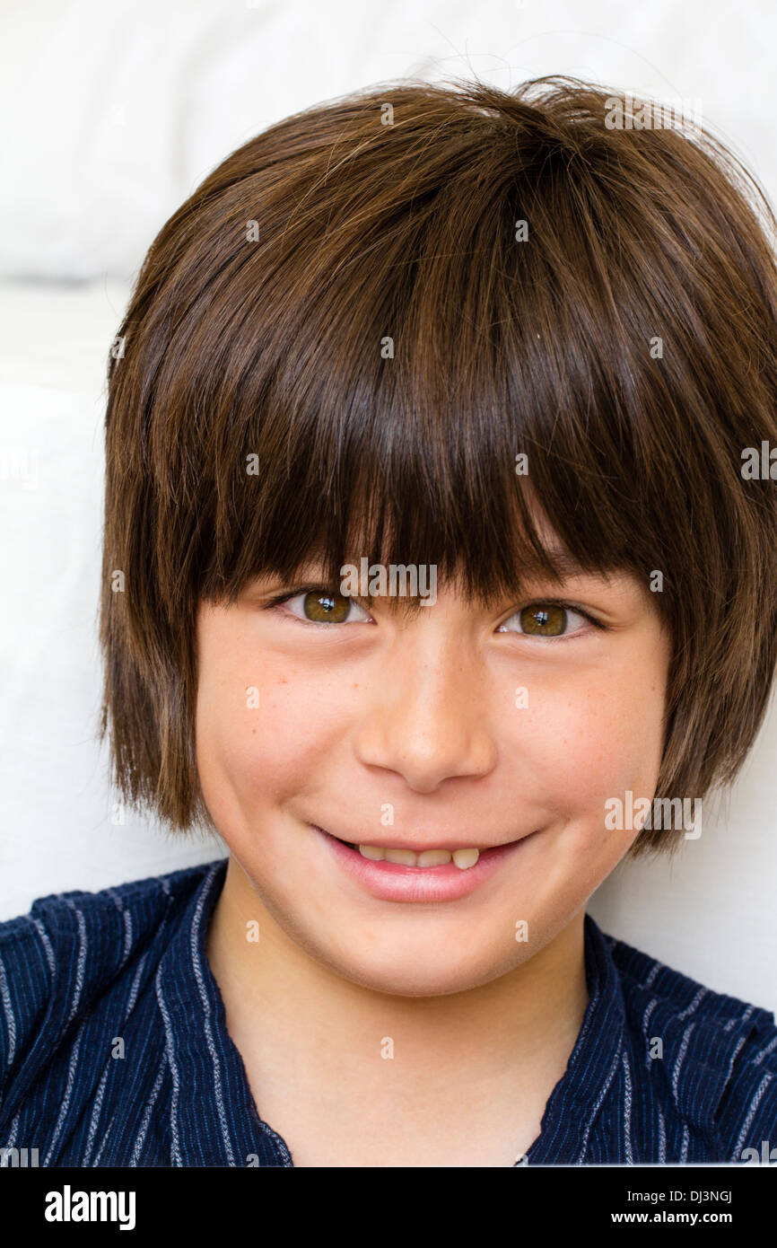 Head and shoulder portrait of a Caucasian male child, boy 10 - 12 year old, face facing viewer, big smile on his face. Eye-contact. Stock Photo