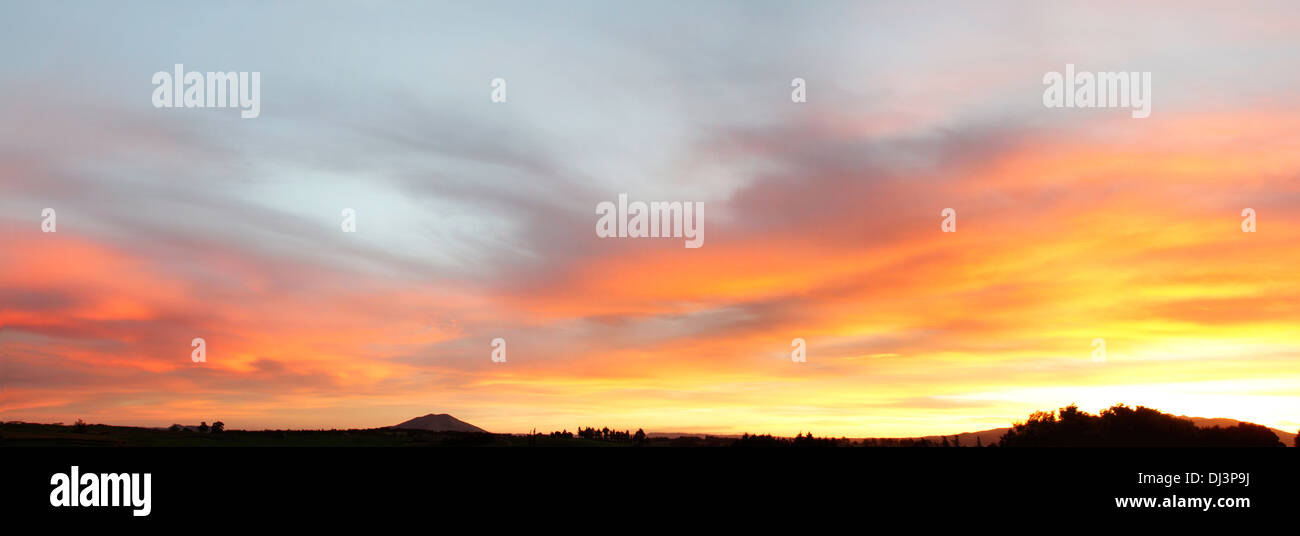 Bright sunset in sky over New Zealand landscape Stock Photo