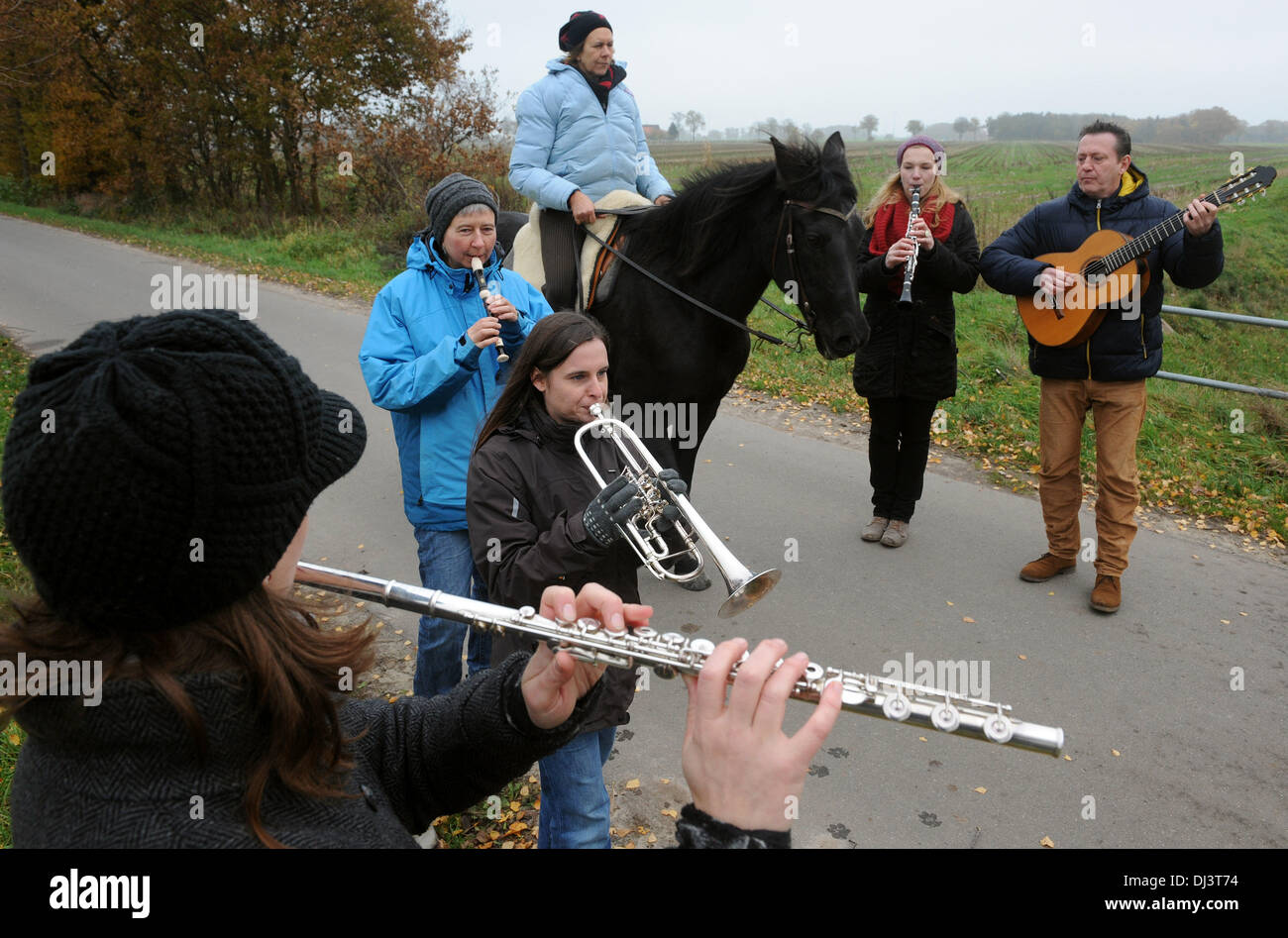 Martfeld, Germany. 16th Nov, 2013. The course director Gwendolyn Schubert plays on her flute to the beat of the hooves of the horse 'Jemala' wich is ridden by Dagmar Fuchs as well as Kristin Mielke on the fipple pipe, Kim Dinter on the trumpet, Stephanie Schmidt on the clarinet and Udo Schneider on the guitar follow the beat in Martfeld, Germany, 16 November 2013. The course shows musicians how to follow the beat of the gait of a horse, which then can be considers as a conductor. Photo: Ingo Wagner/dpa/Alamy Live News Stock Photo