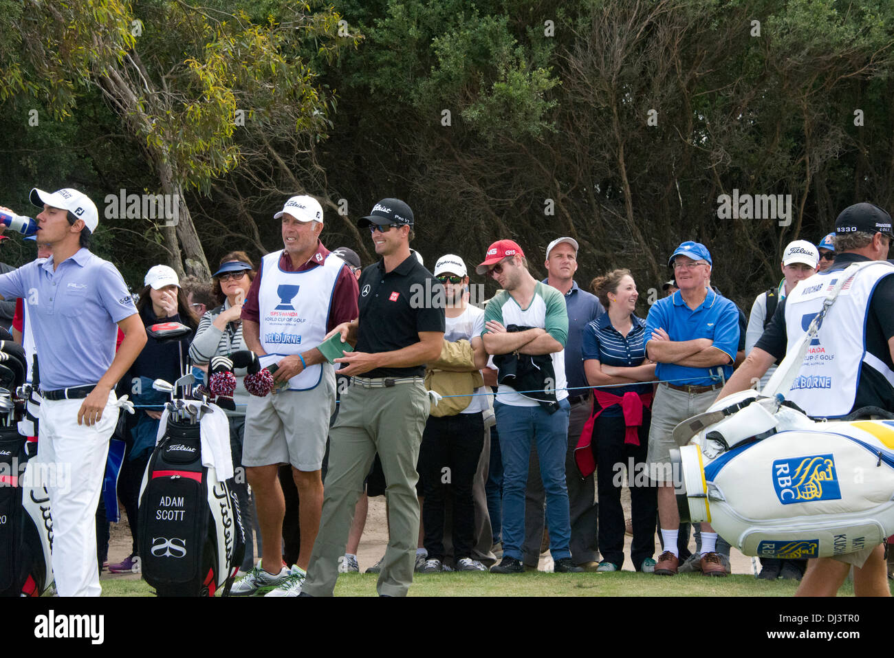 Adam Scott standing with his caddy score card in hand smiling casual with fans onlooking at the world cup royal melbourne 2013 Stock Photo