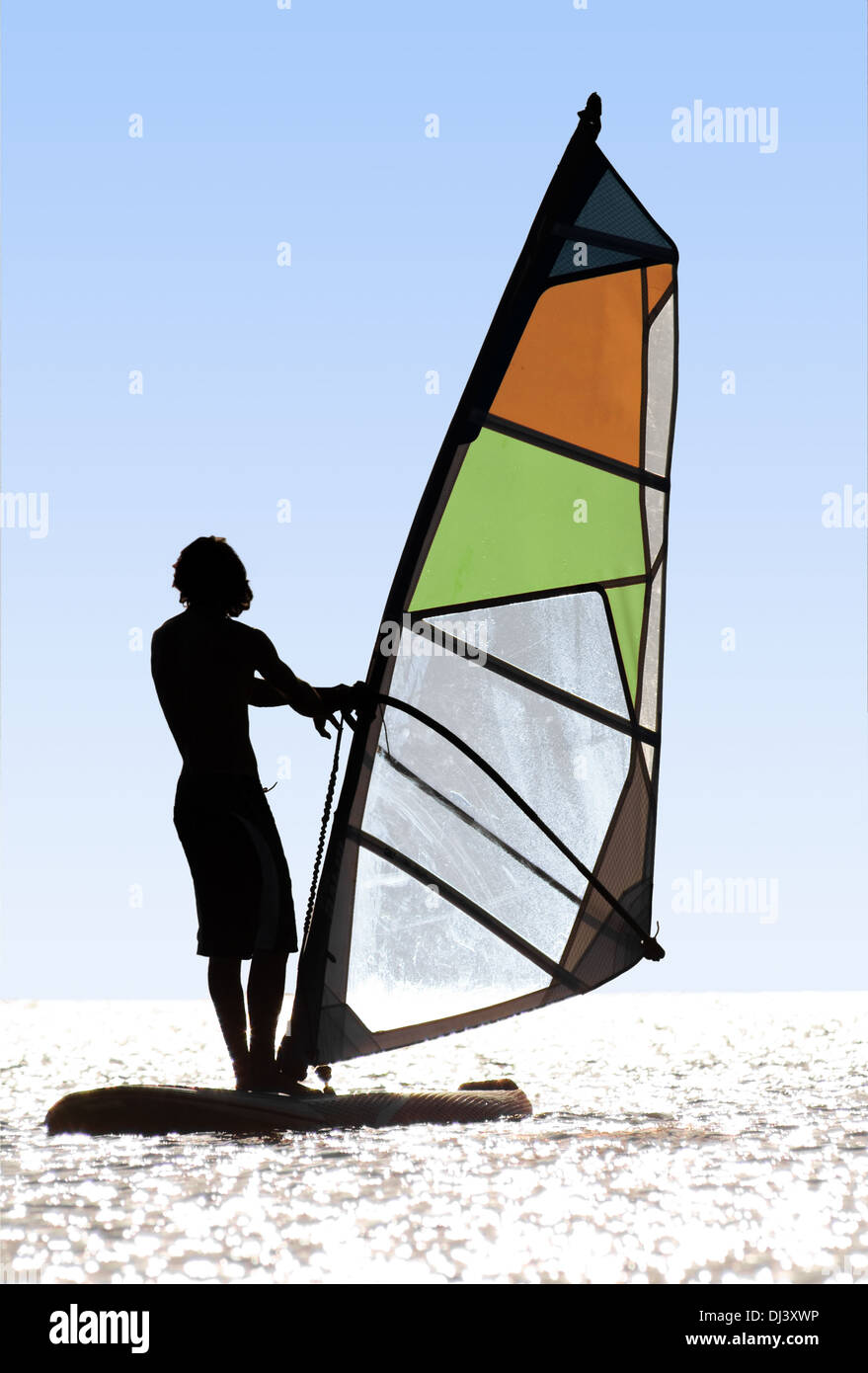 Silhouette of a windsurfer on waves of a bay Stock Photo