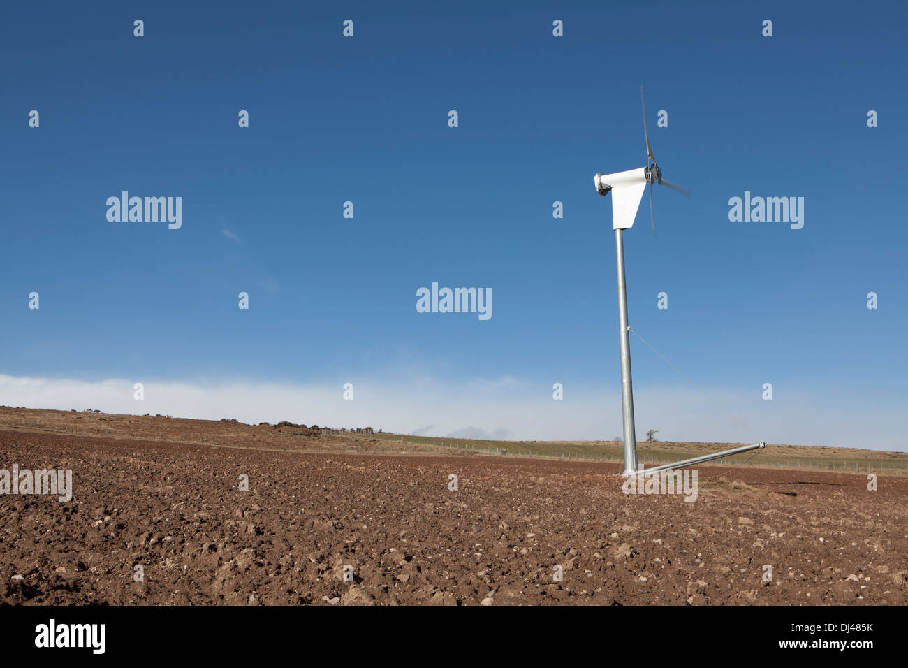Wind turbine against a bright blue sky on a farm Stock Photo - Alamy