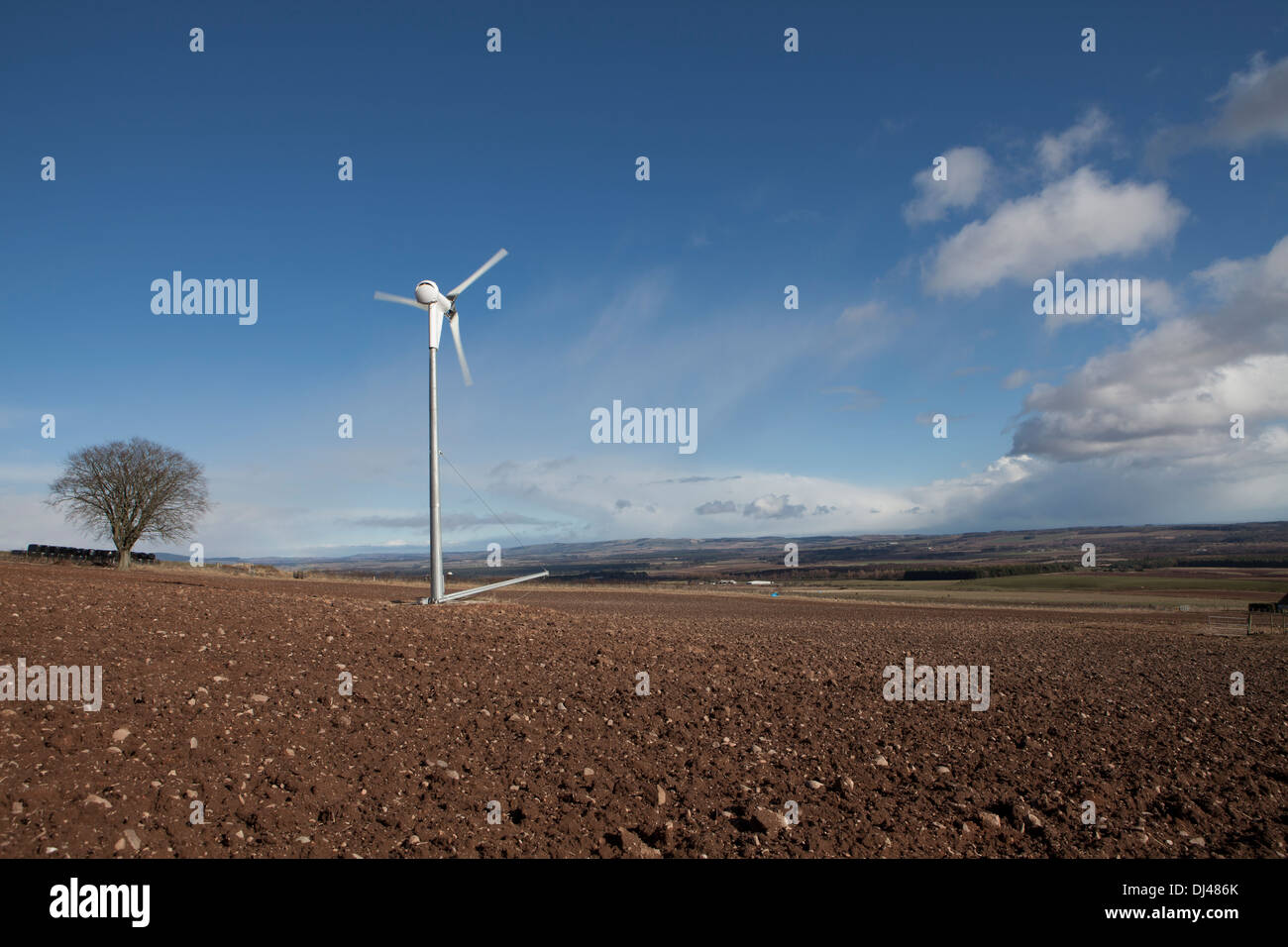 Wind turbine against a bright blue sky on a farm Stock Photo - Alamy