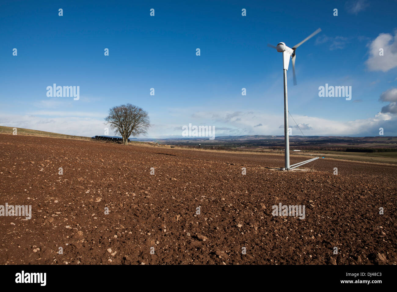 Wind turbine against a bright blue sky on a farm Stock Photo - Alamy