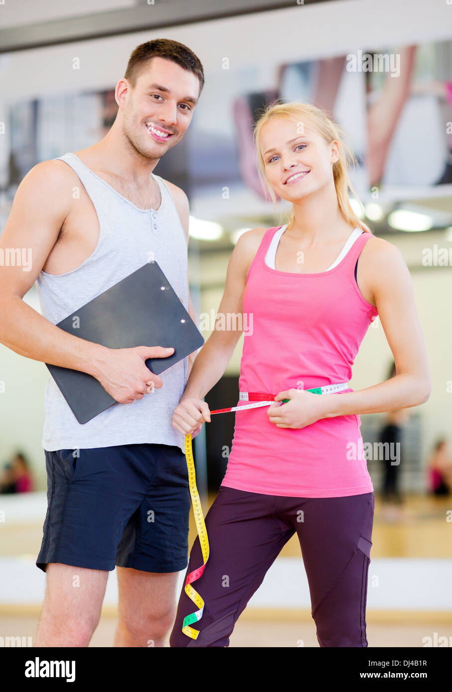 two smiling people with clipboard and measure tape Stock Photo