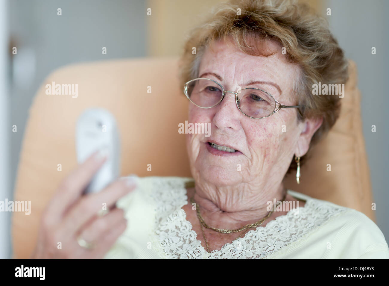 Happy retiree considers her cell phone Stock Photo