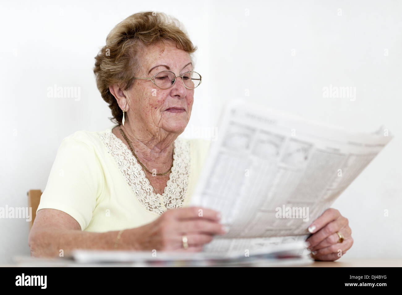 Senior interested in reading the newspaper Stock Photo