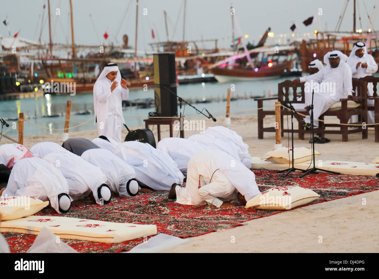 DOHA, Qatar - Nov 21 2013:  Members of a Qatari traditional music group perform evening prayers at the 3rd Traditional Dhow Festival, held at Katara cultural village in the West Bay area of the Qatari capital. Credit:  Art of Travel/Alamy Live News Stock Photo