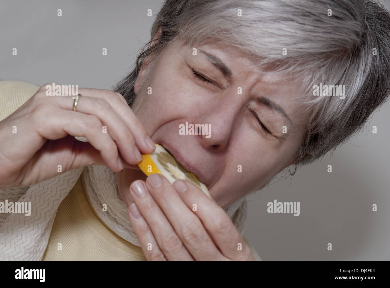 Woman biting into a lemon Stock Photo