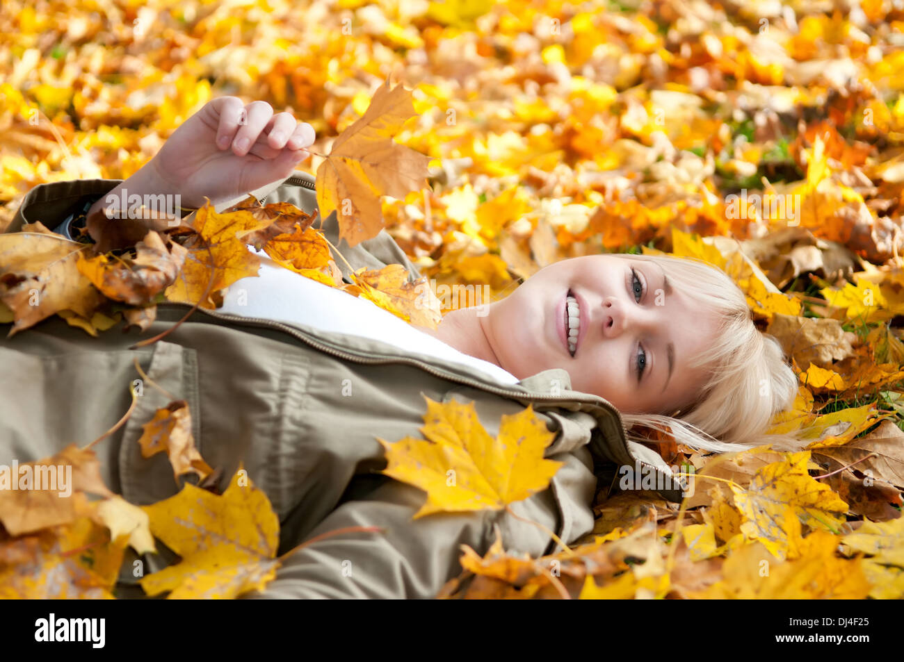 young woman lying in autumn leaves Stock Photo - Alamy