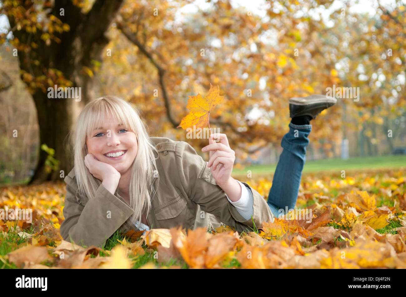 young woman lying in autumn leaves Stock Photo - Alamy