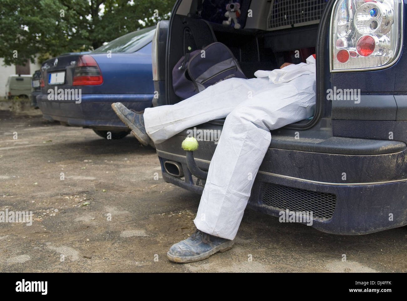 Men's legs sticking out of the trunk Stock Photo