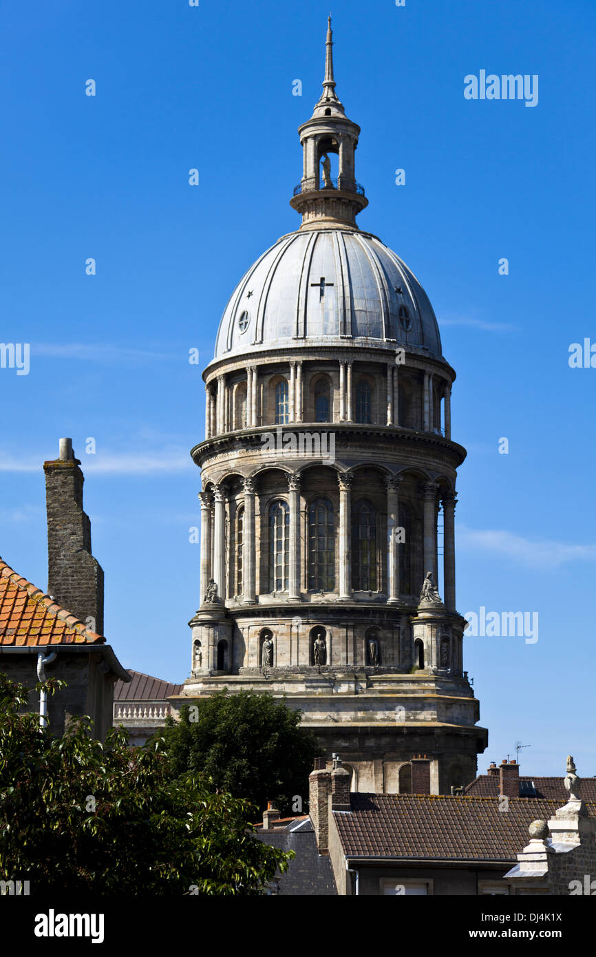 The dome of Notre Dame Cathedral appears above roofs of house in the upper town at Boulogne-sur-Mer against a bright blue sky. Stock Photo