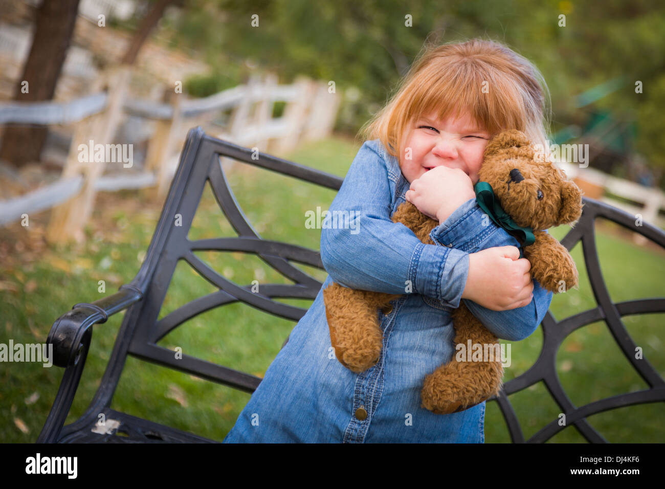 Cute Smiling Young Girl Hugging Her Teddy Bear on Bench Outside Stock ...