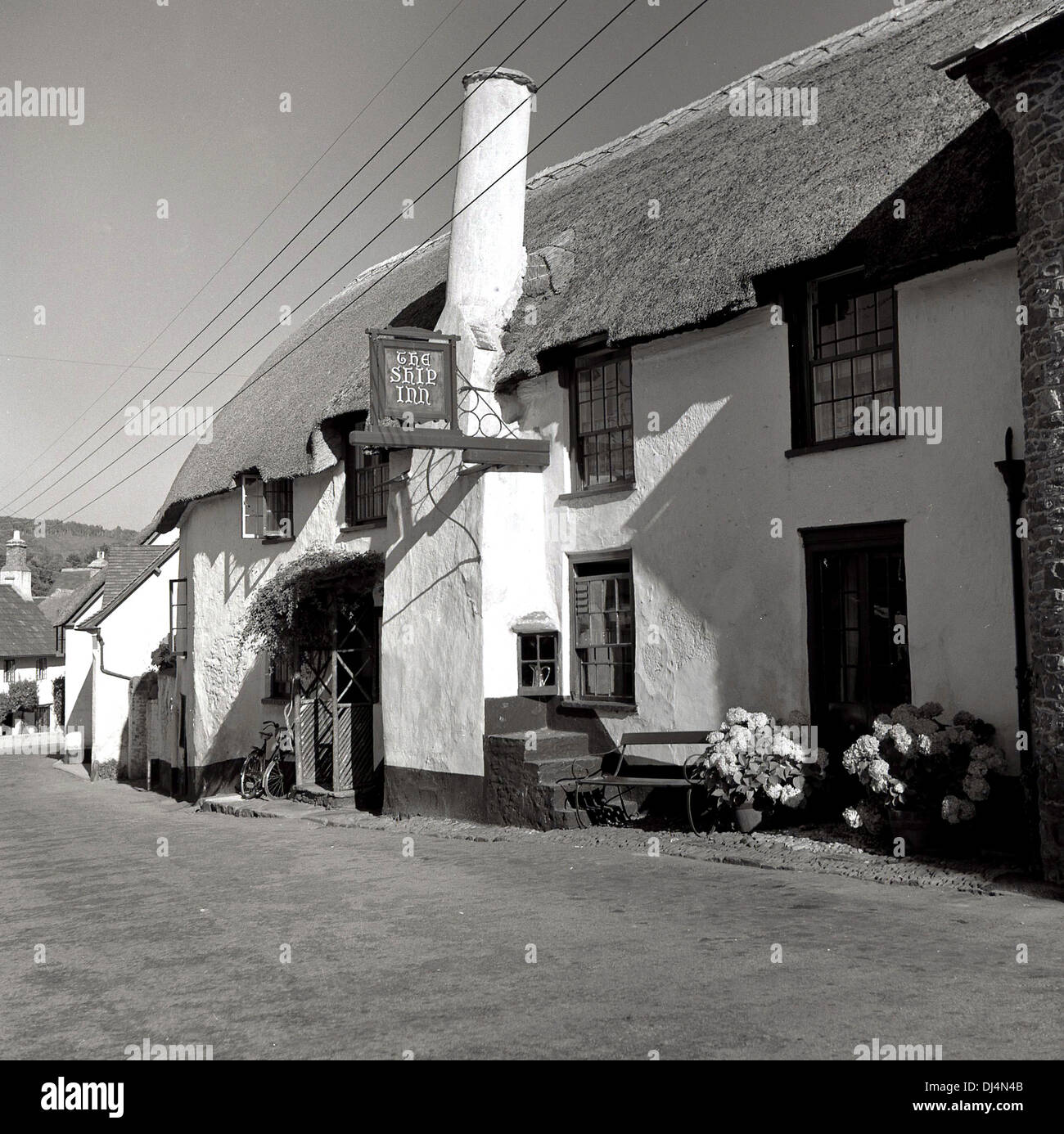 Historical picture from 1950s of The Ship Inn, an old public house or tavern with a thatched roof, located in the high street of the village of Porlock, Somerset, England, UK, set deep into the Exmoor hills. Built in 1290 as a traditional coaching inn with rooms, it is known locally as the Top Ship and is one of the oldest inns on Exmoor. Stock Photo