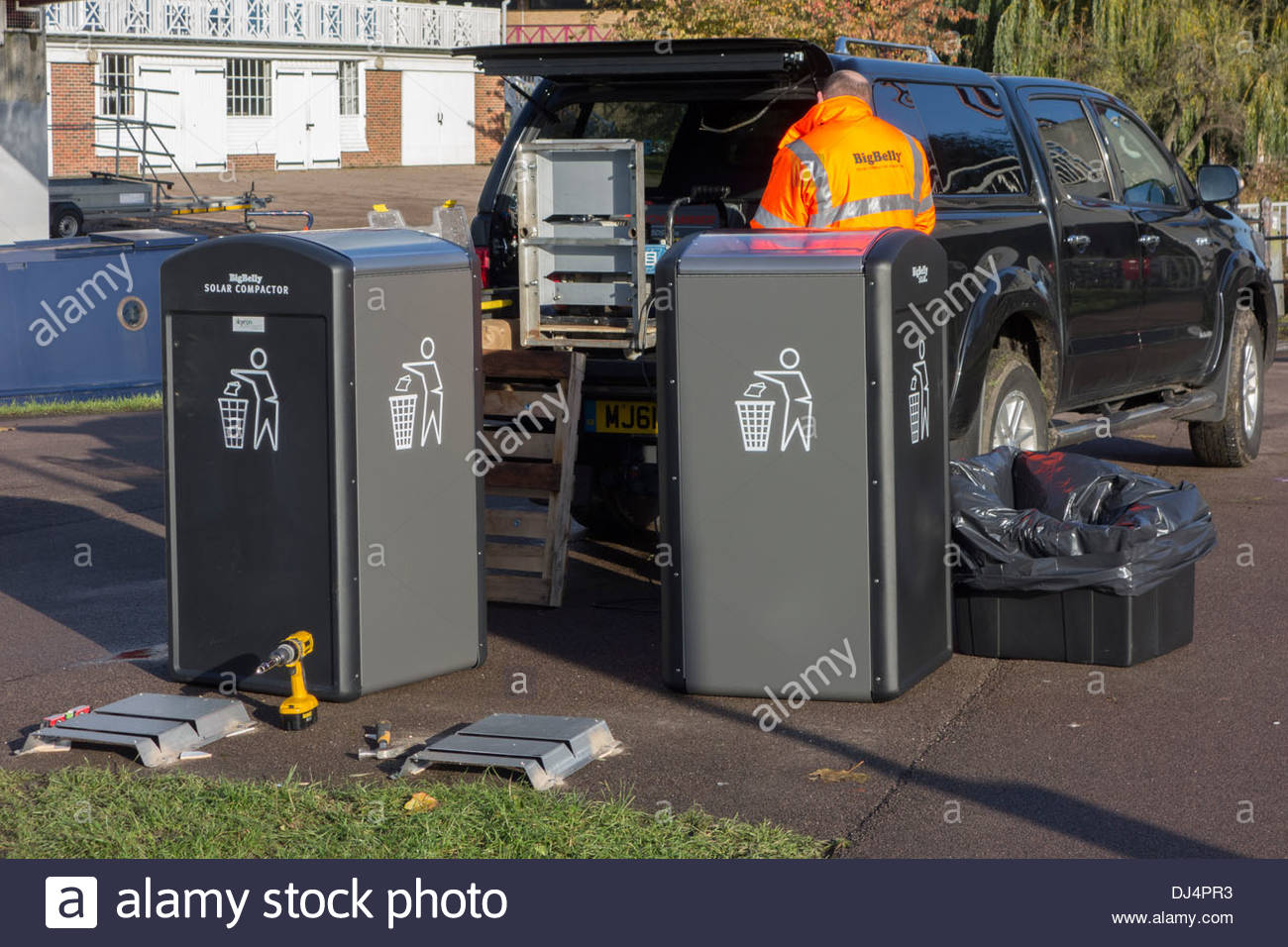 Engineer installing Big Belly Solar Compactor waste bins in Stock Photo