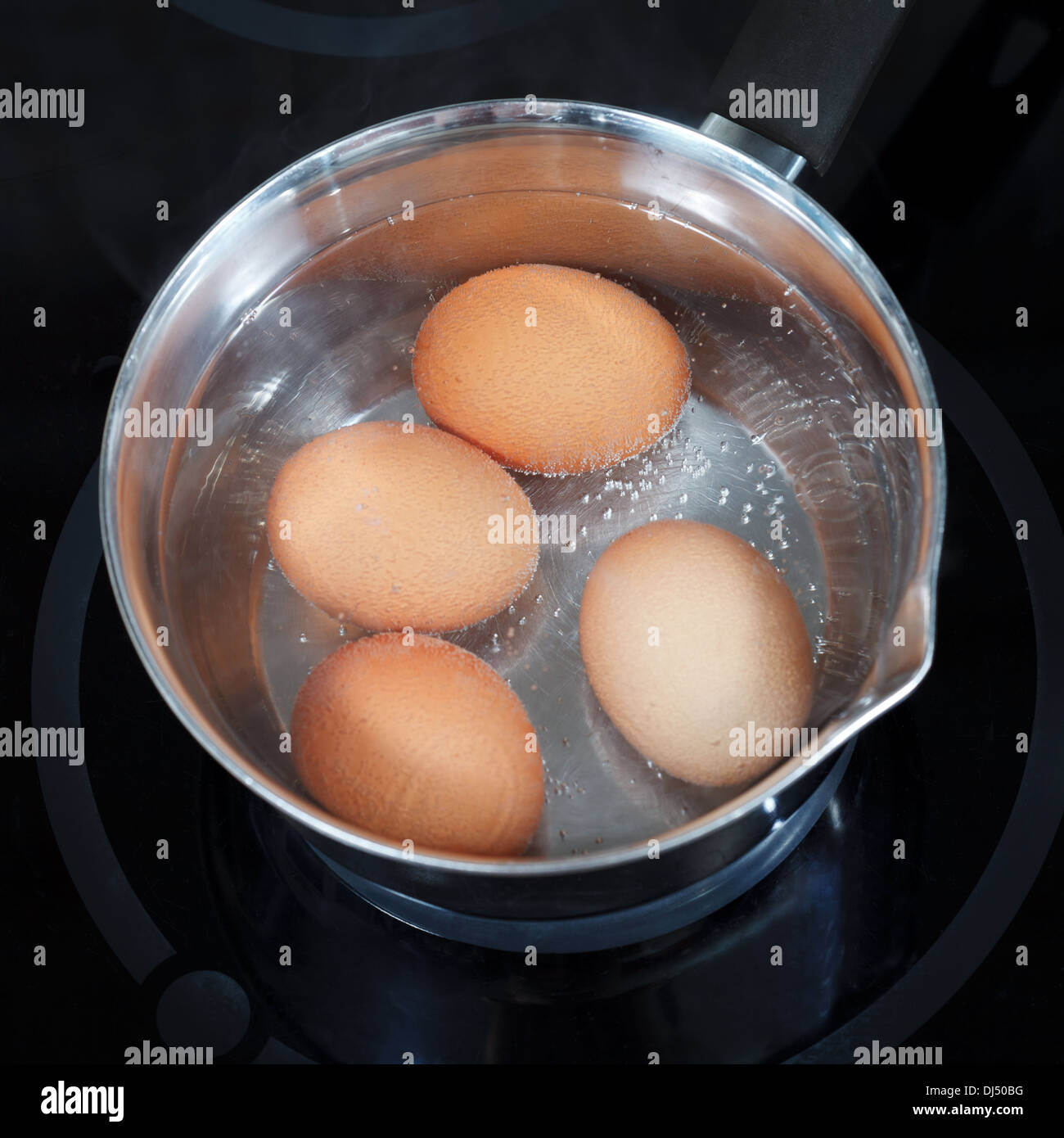 top view of boiling chicken eggs in metal pot on electric stove in kitchen Stock Photo