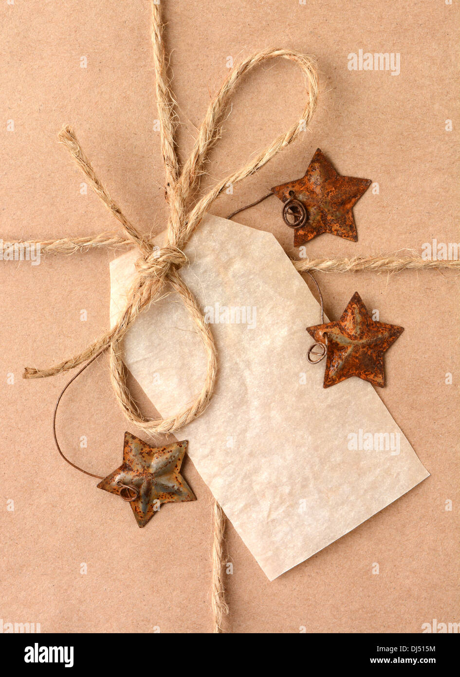 Closeup of a gift tag on a Christmas present. The package is wrapped in plain brown paper with a tied with twine. Stock Photo