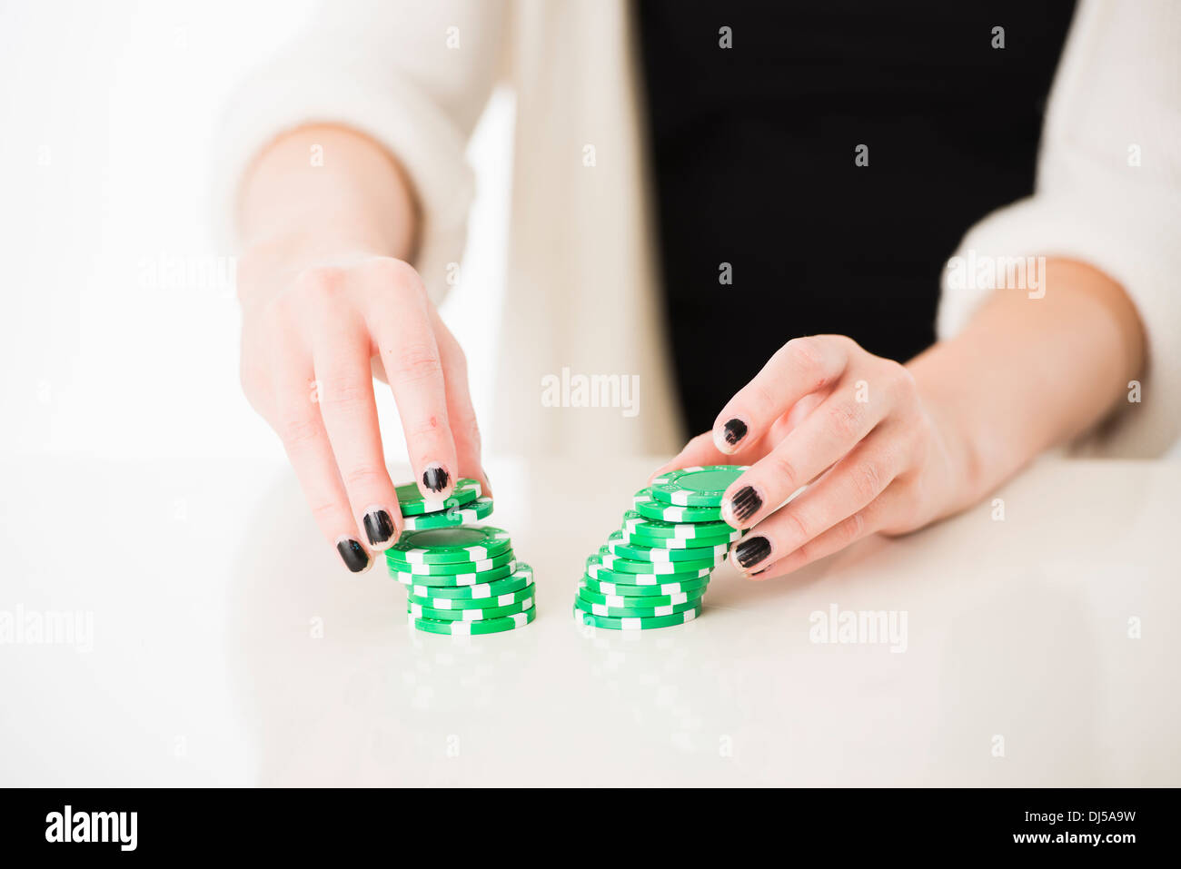 Hands of woman holding green poker chips Stock Photo