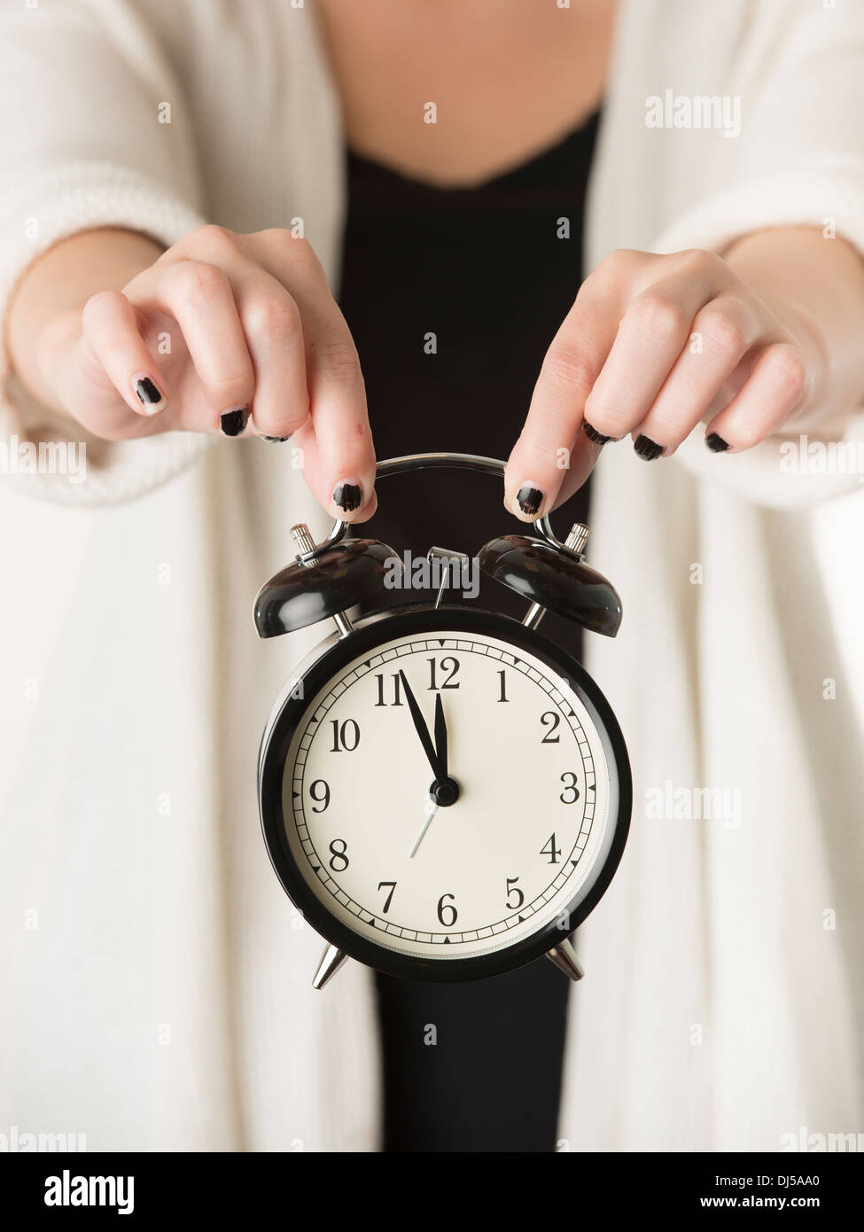 Hands of woman holding alarm clock Stock Photo