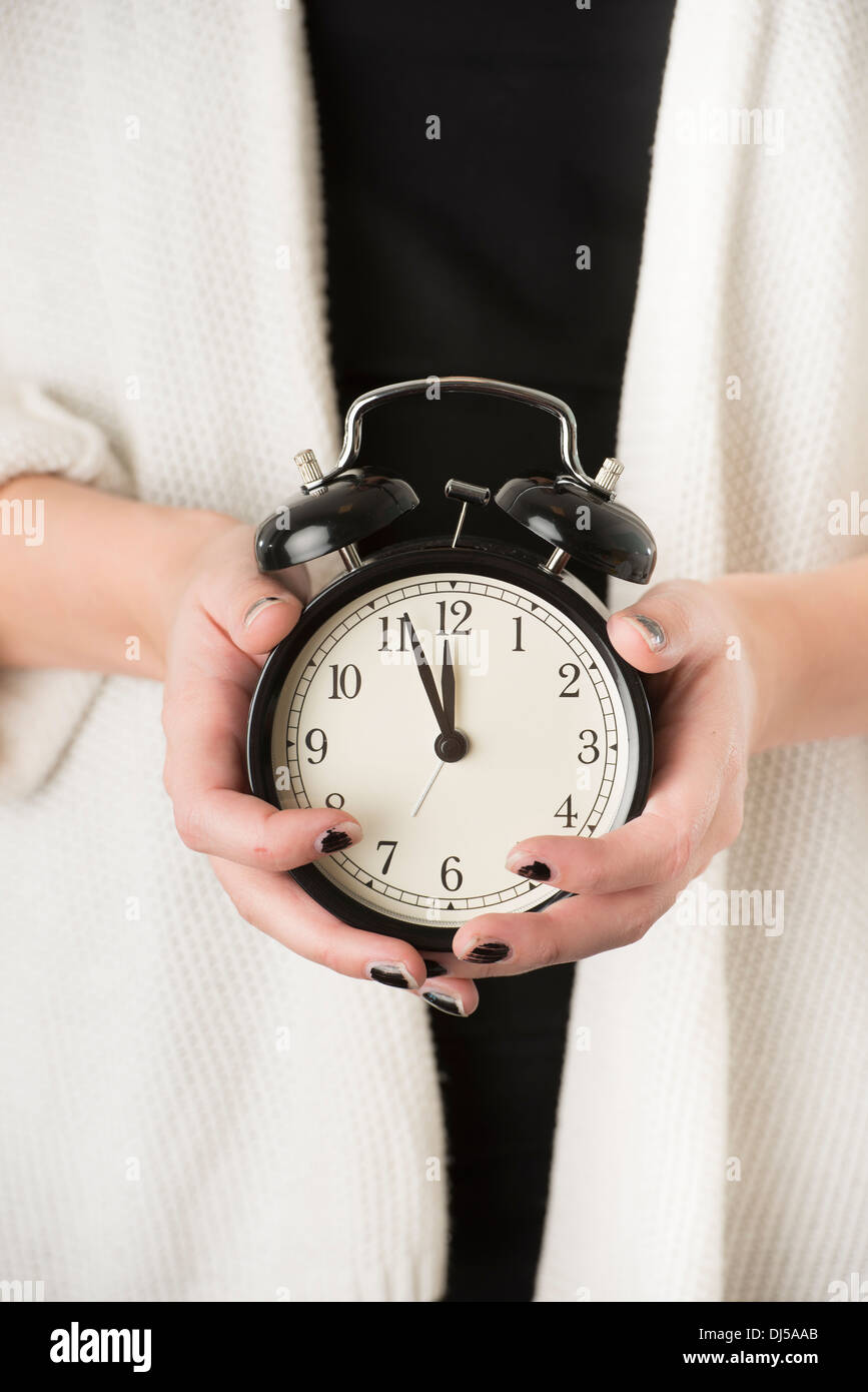 Hands of woman holding alarm clock Stock Photo